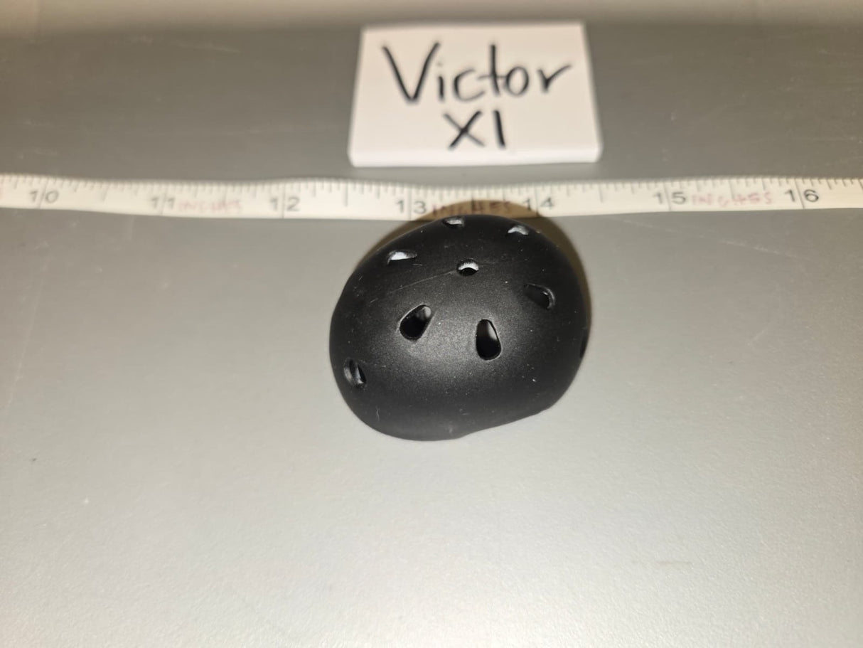 Looking at the object, it appears to be a miniature skateboard/skate helmet with ventilation holes. The ruler shows it spans approximately 1.5 inches, consistent with 1/6 scale. 1/6 Scale Modern Era Skate Helmet - Victor XI