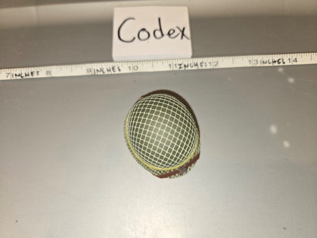 Using the ruler, the mesh screen dome is approximately 1.5 inches wide, consistent with a 1/6 scale microphone windscreen/mesh head. The tag reads "Codex." 1/6 Scale Modern Era Broadcast Microphone Mesh Windscreen - Codex