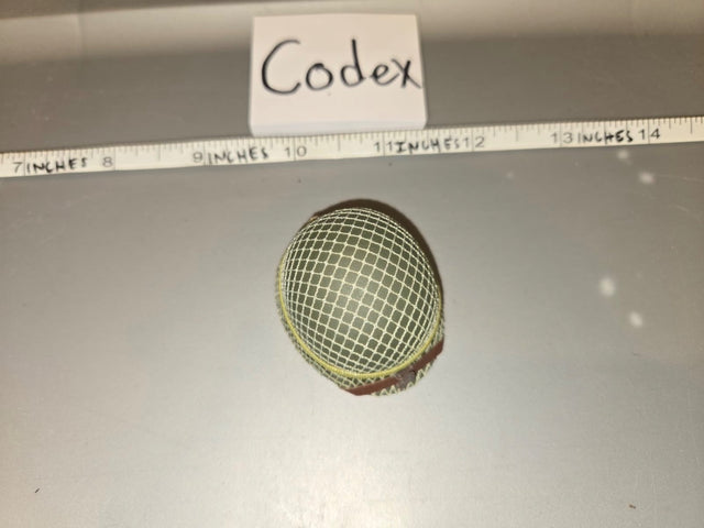 Using the ruler, the mesh screen dome is approximately 1.5 inches wide, consistent with a 1/6 scale microphone windscreen/mesh head. The tag reads "Codex." 1/6 Scale Modern Era Broadcast Microphone Mesh Windscreen - Codex
